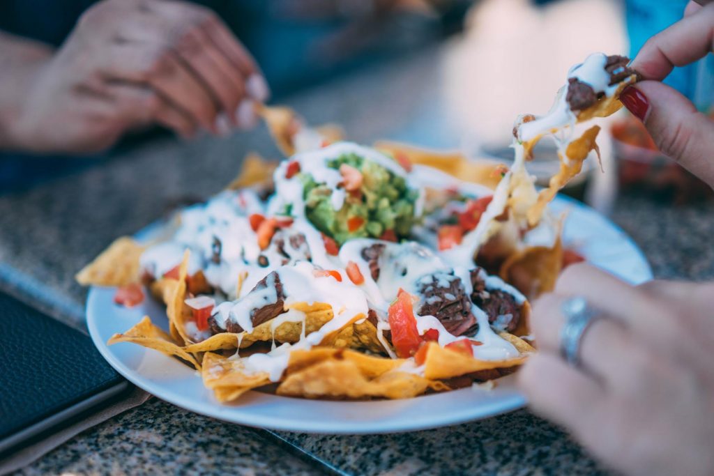 A plate of greek yogurt tortilla chips being shared