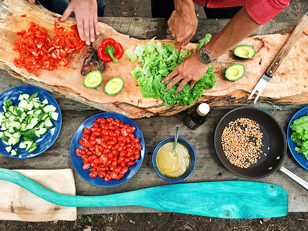 people preparing a salad spread