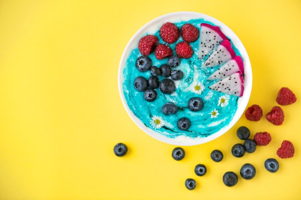 A colourful yogurt bowl with raspberries, dragonfruit and blueberries