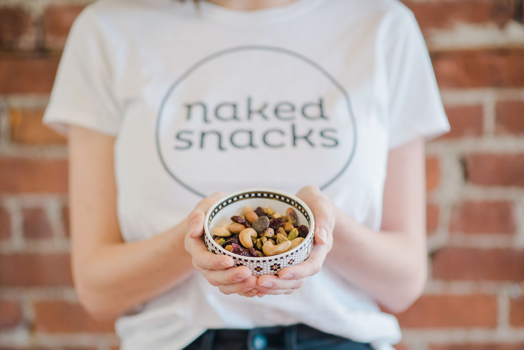 A woman holding a bowl of Tuscan Road Trip Naked Snacks