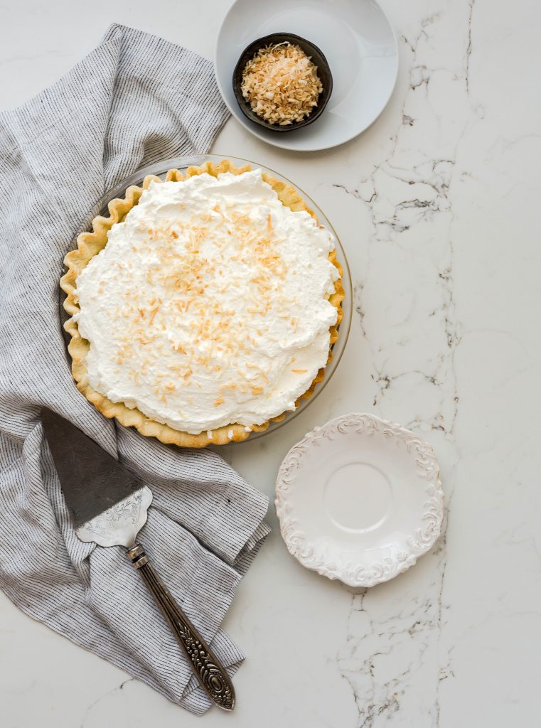 coconut cream pie on marble background, with serving fork and plate
