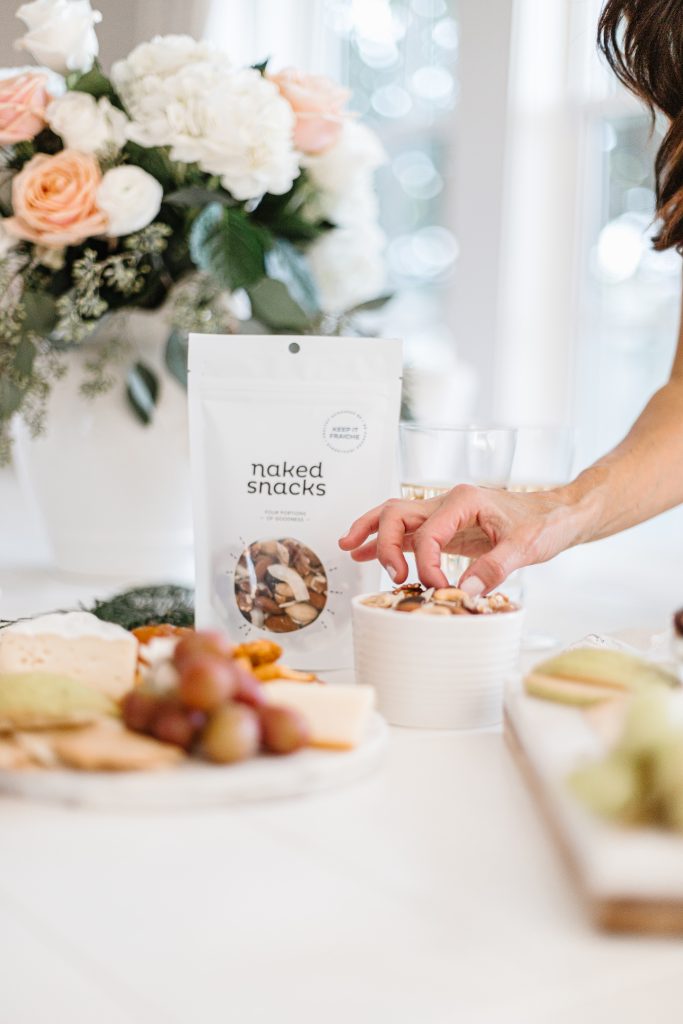 Holiday table with Keep it Fraiche snack and a hand holding a snack.