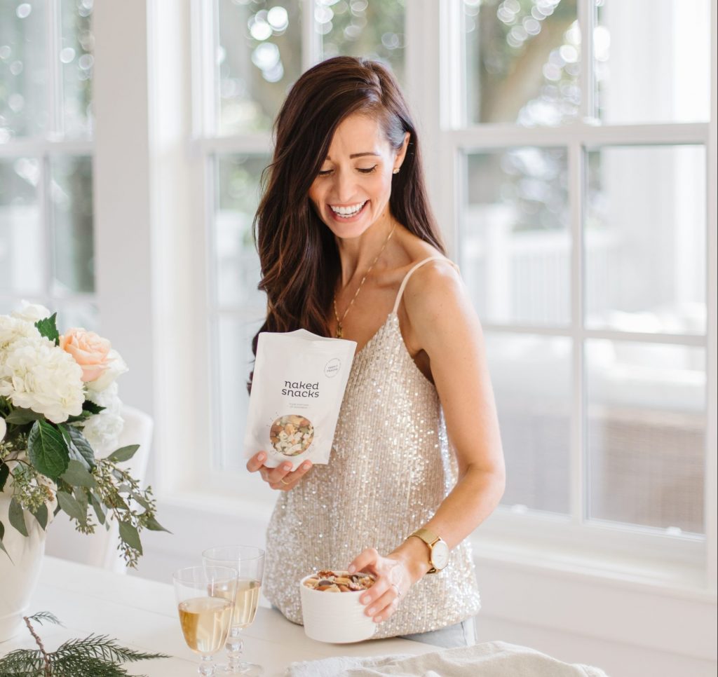 Tori Wessner holding a bag of Keep it Fraiche Snack, in a bright kitchen