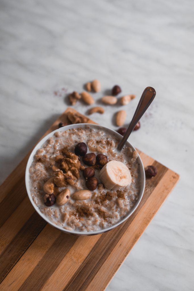 a bowl of oatmeal, with bananas and nuts