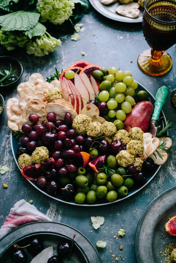 a holiday plate of fruits and high-fibre foods, with grapes, olives, crackers,  apples