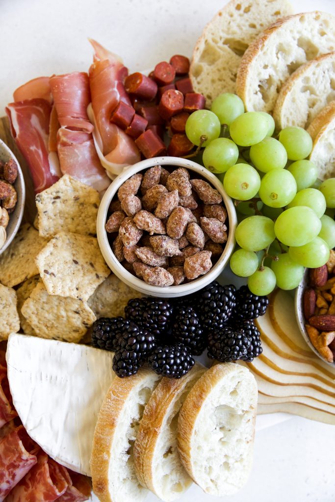 charcuterie board with fresh grapes, curated meats and Laid Back Snacks Maple Praline Almonds