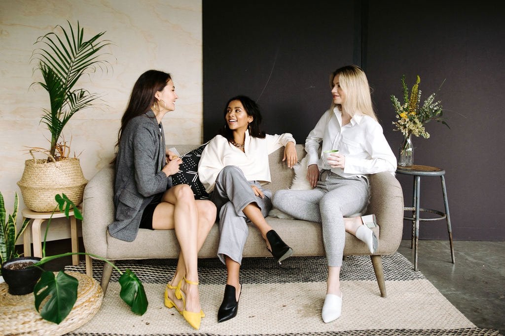 Three women sitting next to each other wearing Leze the Label